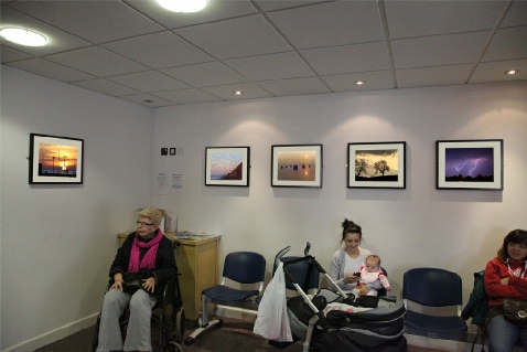 Justyna Dakowicz cleaning photograph in frame after installation.
